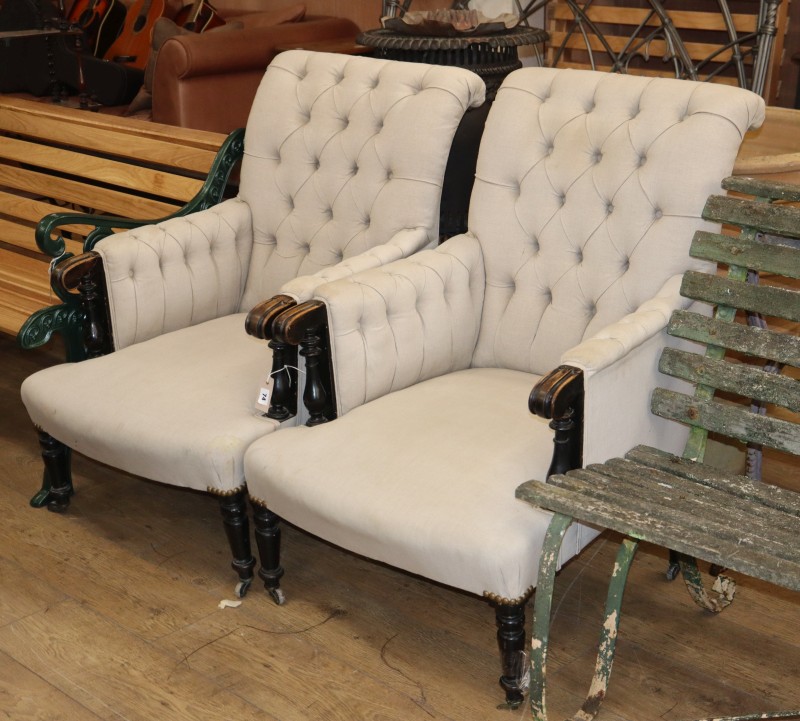 A pair of late Victorian ebonised armchairs upholstered in buttoned fabric
